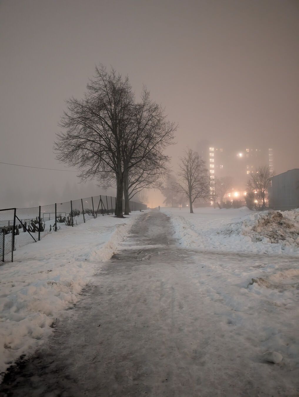 En tåkete og våt gangvei i et boligfelt