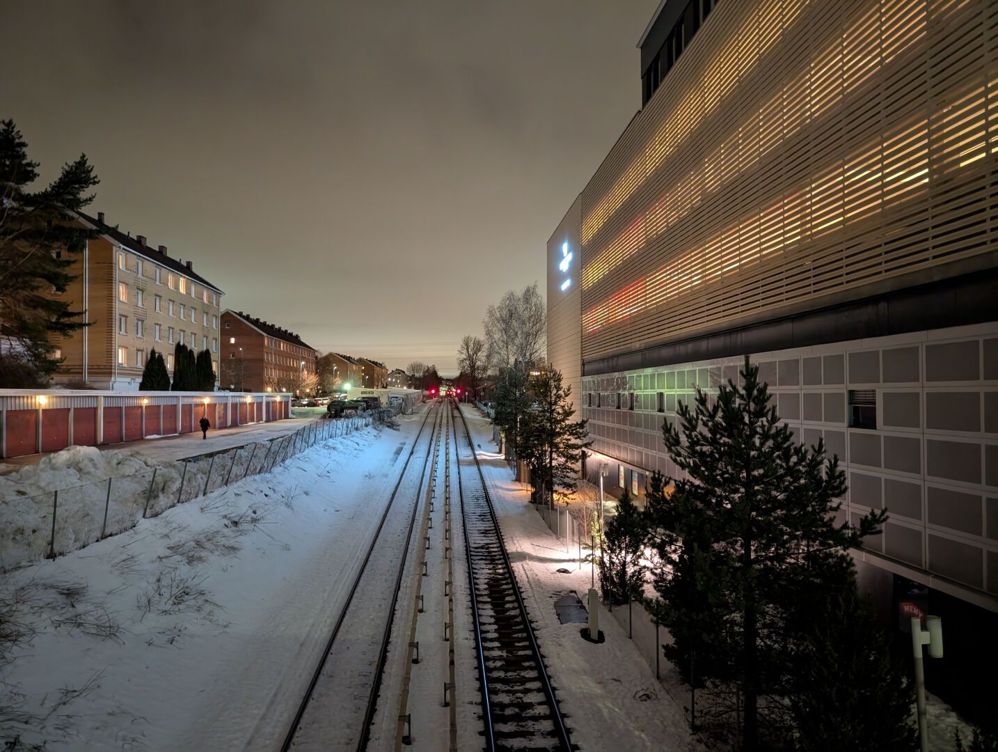 T-banespore går straka veien til Karlsrud, det er mørkt, men lysforurensningen og skydekket lyser likevel kraftig opp